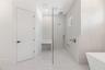 The luxurious primary suite offers a spa-inspired retreat featuring a freestanding soaking tub, oversized walk-in shower with rain head and handheld s