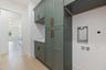 Designed with both beauty and functionality in mind, the laundry room offers elegant Shaker Ivy cabinetry, abundant storage with tall cabinets, stacka