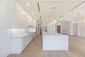 The gourmet kitchen is a true showpiece, featuring full-height custom cabinetry, an oversized 11-foot quartz island with storage on both sides, marble