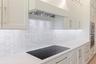 The gourmet kitchen is a true showpiece, featuring full-height custom cabinetry, an oversized 11-foot quartz island with storage on both sides, marble