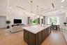 Virtually staged.The gourmet kitchen is a true showpiece, featuring full-height custom cabinetry, an oversized 11-foot quartz island with storage on b