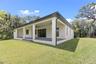 Covered paver lanai, pre-plumbed for a future outdoor kitchen, overlooking the beautifully landscaped yard with premium St. Augustine sod and mature n