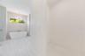 The luxurious primary suite offers a spa-inspired retreat featuring a freestanding soaking tub, oversized walk-in shower with rain head and handheld s