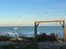 A cozy oceanside swing, gently swaying with the ocean breeze.