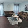 Spacious living area featuring dark wood-finish flooring, recessed lighting, and ample natural light from multiple windows