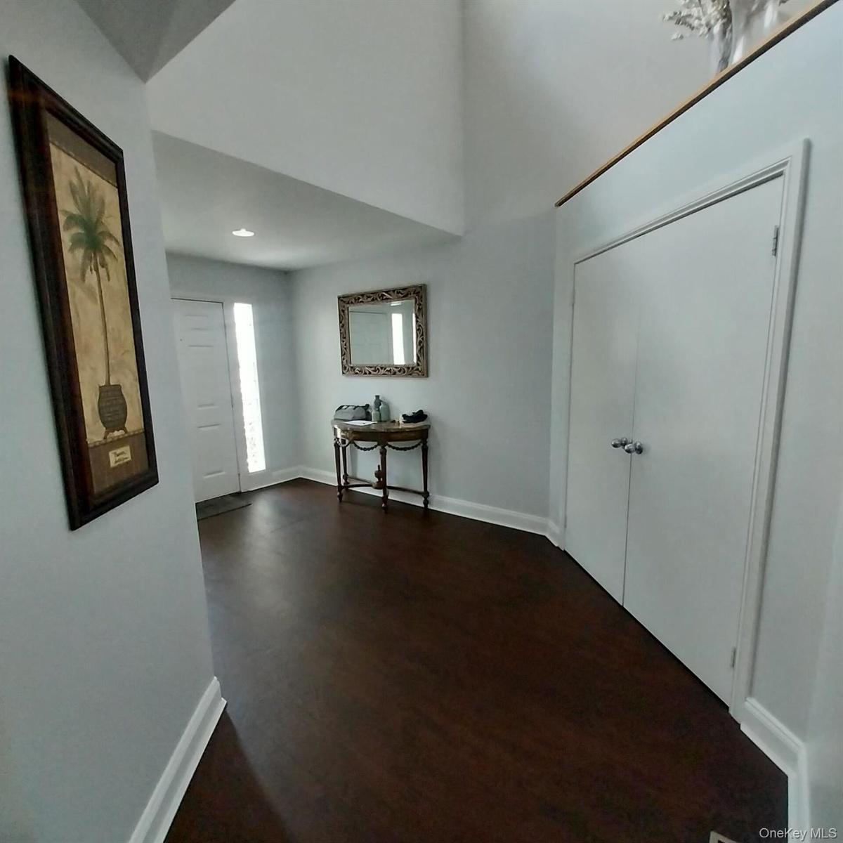 Entryway featuring dark wood-finish flooring, white baseboards, and light gray walls
