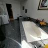 Built-in jetted tub surrounded by a polished stone countertop, featuring an integrated faucet