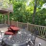 Multi-level wood deck featuring a natural wood finish, extensive balustrade, and a mature tree canopy