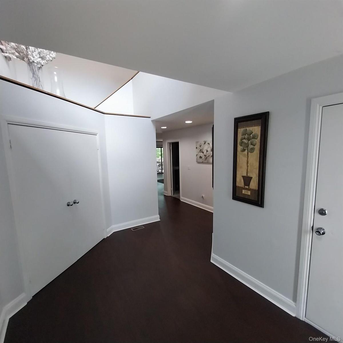 Entryway featuring dark wood-finish flooring, white baseboards, and light gray walls