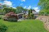 Colorful specimen trees, mature landscaping, and generous lawn space frame the pool area with beauty and privacy.