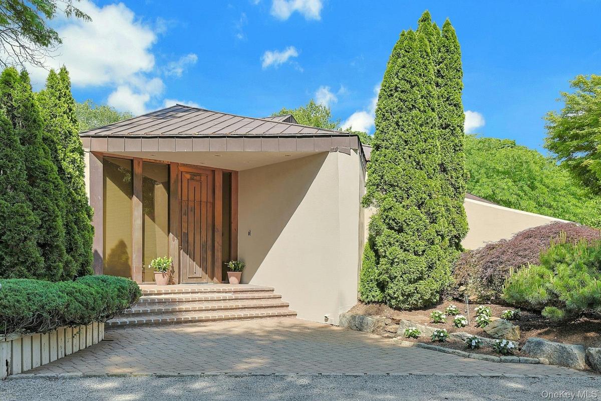 A dramatic copper entry door and striking architectural lines create a memorable first impression upon arrival.
