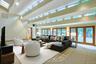 The extraordinary double-height family room showcases soaring ceilings, walls of glass, and seamless indoor-outdoor living.