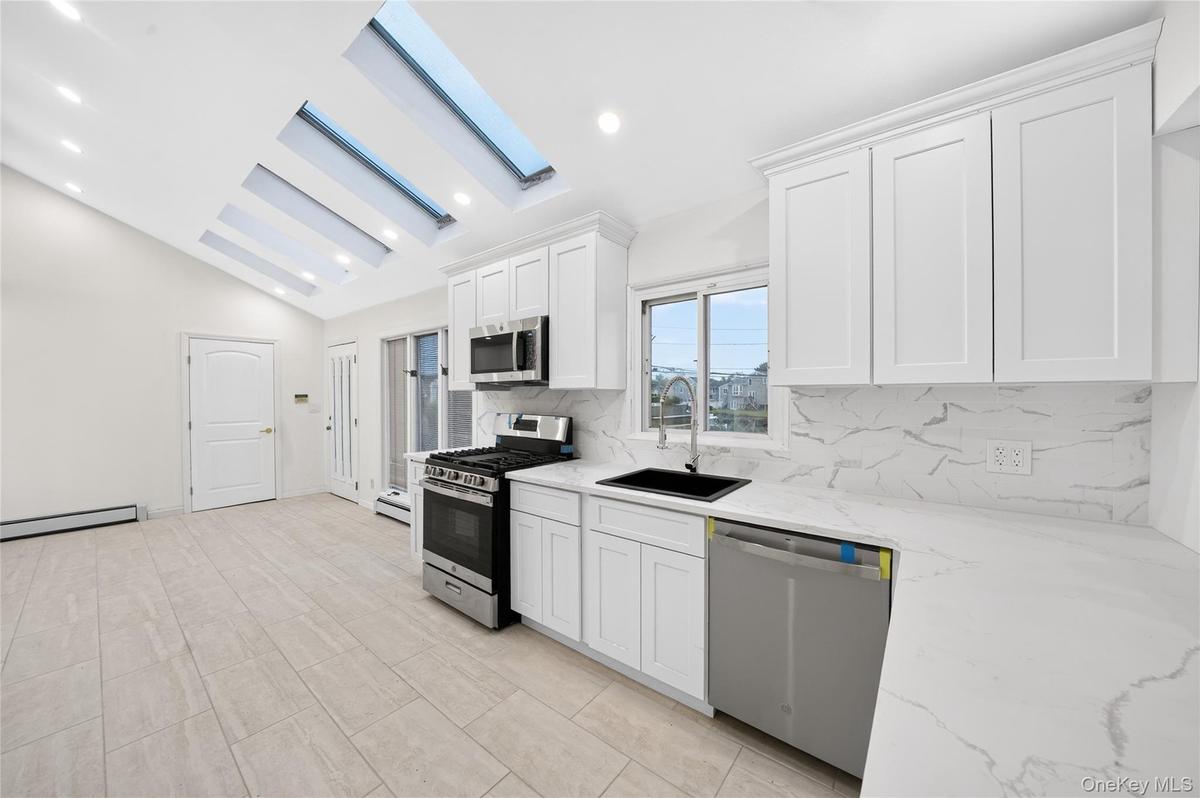 Kitchen with high ceiling and skylights