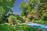 Rectangular in-ground swimming pool with stone coping and surrounding lawn