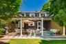 Expansive wood-finish deck with pergola structure, white columns, and a lattice privacy screen