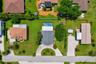 Overhead drone view highlighting the property layout, circular driveway, pool, and spacious yard.