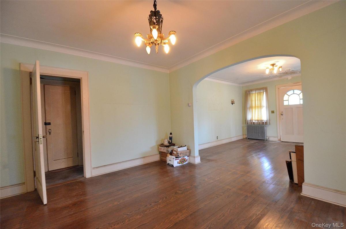 Dining Room featuring a solid wood door, hardwood flooring, and crown molding