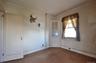 Bedroom featuring hardwood flooring, light-toned walls, white trim