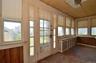 Sunroom featuring wood-paneled walls, wood-finish flooring, and a wood-plank ceiling