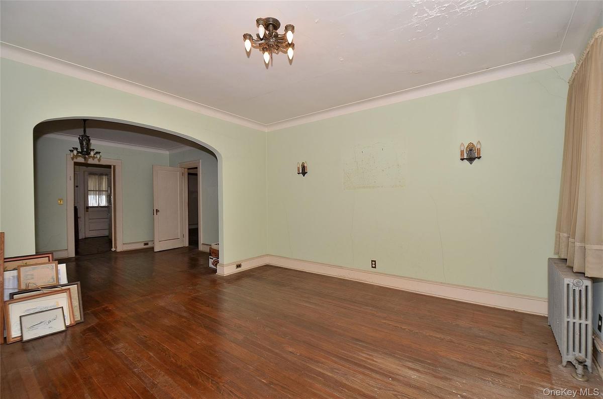 Living Room featuring a solid wood door, hardwood flooring, and crown molding