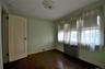 Bedroom featuring wood-finish flooring, a baseboard radiator, and light green wall paint
