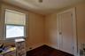 Bedroom featuring hardwood flooring, light-toned walls, white trim