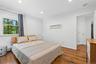Spacious room featuring wood-finish flooring, recessed lighting, and a large window