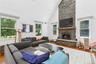 Living area featuring a floor-to-ceiling stone wood fireplace with a wood mantel