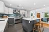 Modern kitchen featuring a large center island, contrasting two-tone cabinetry, stainless steel appliances, a tile backsplash, and recessed lighting