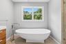 Freestanding soaking tub with a floor-mounted chrome filler