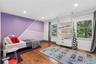 Hardwood flooring in a spacious room featuring two large windows, recessed lighting, and a built-in shelving unit with drawer storage