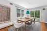 Dining area featuring wood-finish flooring, a contemporary pendant light fixture, and a sliding glass door providing access to an exterior deck