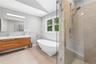 Contemporary bathroom featuring a frameless glass shower enclosure, a freestanding soaking tub with a floor-mounted faucet, a floating double vanity w