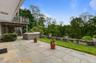 The rear flagstone patio just steps outside the lower level, and also steps off the Trex Deck on the main floor.