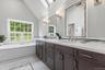 The marble Primary Bathroom was redone in 2015 with two heated towel racks, plantation shutters & a skylight over the Kohler soaking tub.