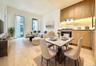 Open-concept living space featuring wood-finish flooring, a contemporary kitchen with wood cabinetry and stone backsplash, and floor-to-ceiling window