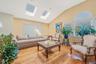Living area featuring vaulted ceiling, a skylight, and wood finished floors