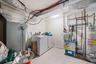 Washroom featuring water heater, washing machine and dryer, light tile patterned flooring, heating unit, and a heating unit