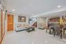 Living room with recessed lighting, light tile patterned flooring, and stairs