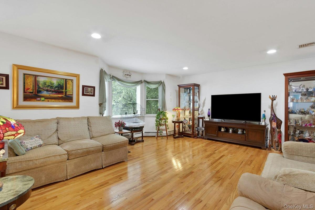 Living room with hardwood floors, recessed lighting, sunlight