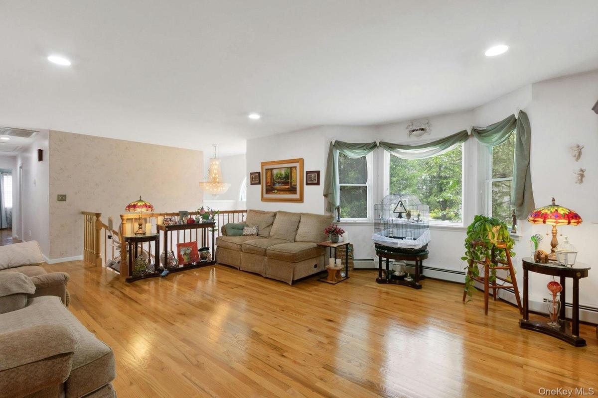 Living room with hardwood floors and bay window, recessed lighting