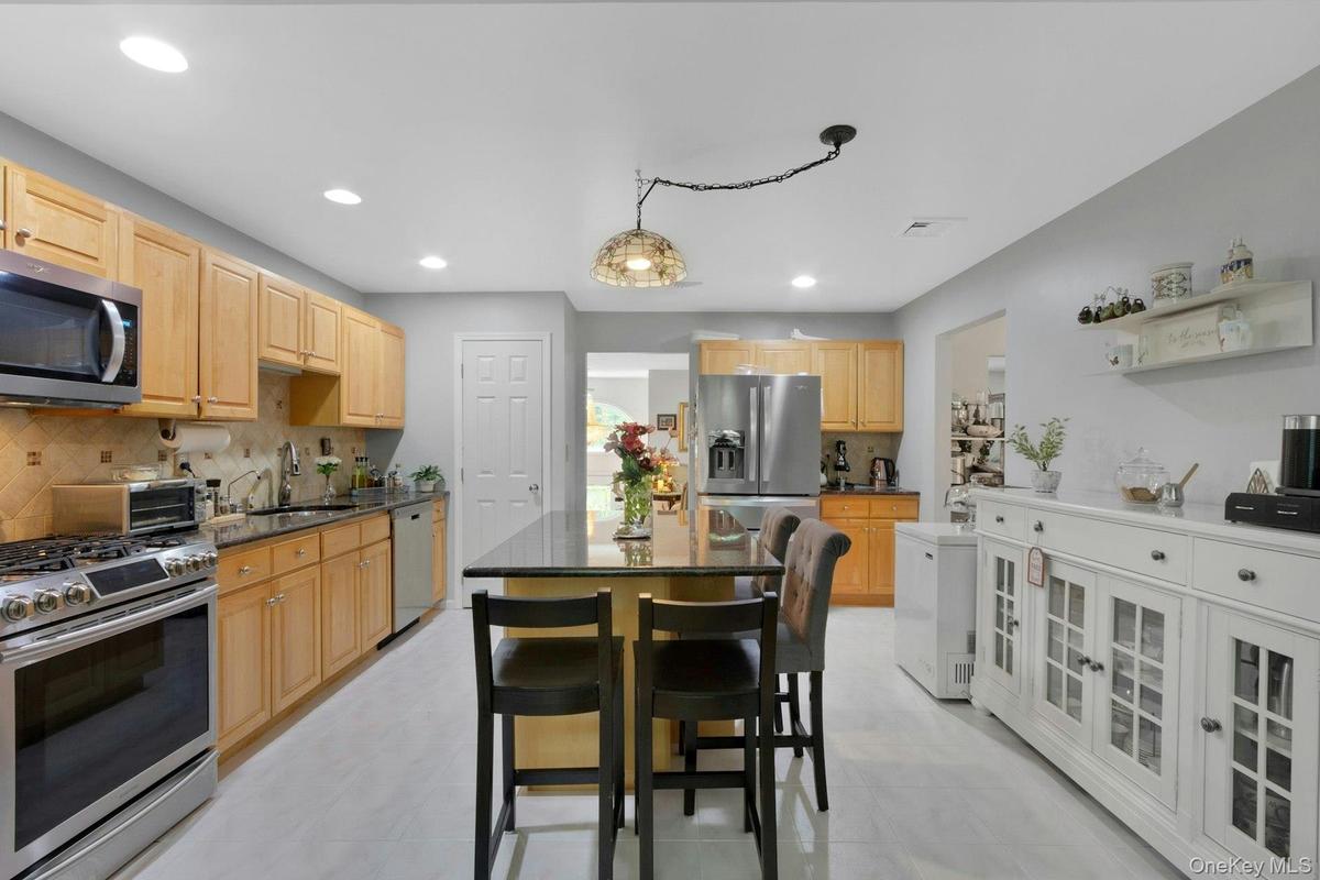Kitchen with movable island, stainless appliances, recessed lighting