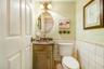 Charming custom 1/2 bath off kitchen with river rock floor tile.