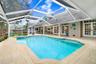 Custom shaped pool with swim seat, spa with spillover ledge feature.