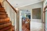 Staircase with crown molding, arched walkways, a ceiling fan, wood-type flooring, and wainscoting