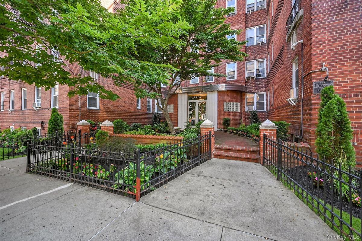 Front entrance with immaculately maintained landscaping offers a warm welcome to this pre-war building