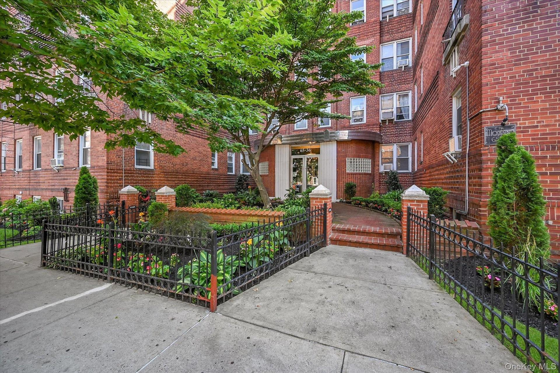 Front entrance with immaculately maintained landscaping offers a warm welcome to this pre-war building