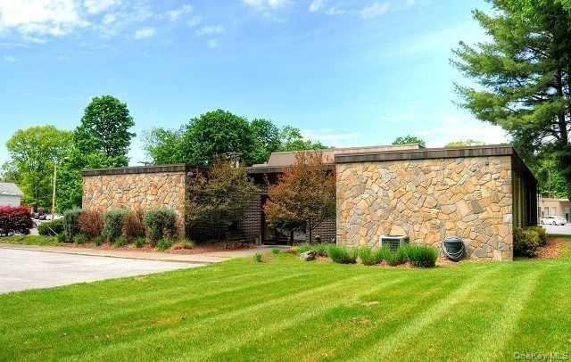 Beautiful stone facade with recessed entrance adorned with mature landscaping.
