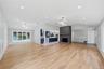 Spacious interior featuring wood-finish flooring, a fireplace with a dark mantel, and recessed lighting