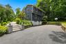 Driveway, 2 car garage with basketball hoop, stairs up to front porch/entry into home.
